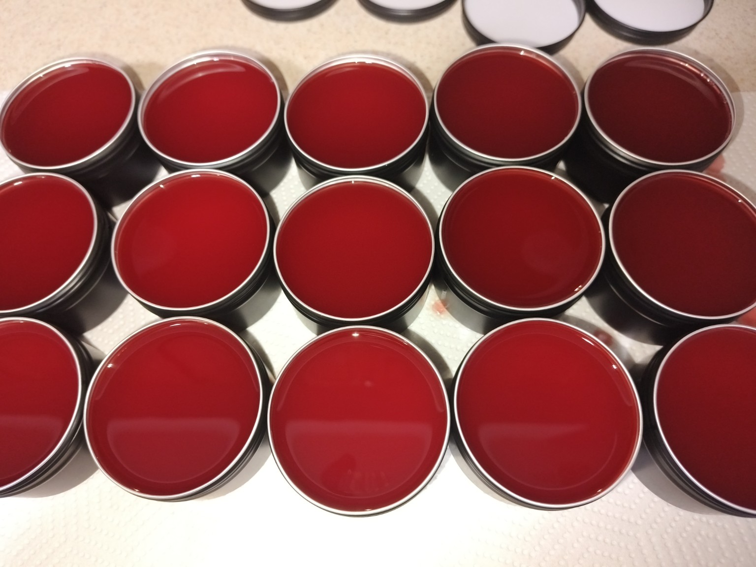 Freshly prepared batch of red HerbMeds salves in open tins